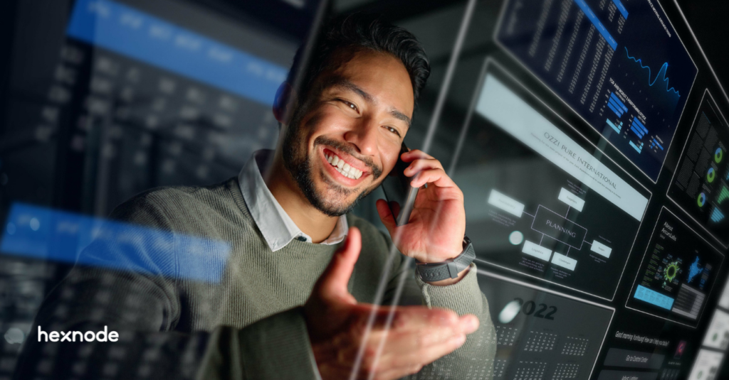 A smiling IT professional on a phone call, viewing a glowing digital dashboard overlay representing an intuitive unified endpoint management interface.