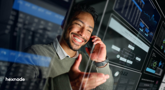 A smiling IT professional on a phone call, viewing a glowing digital dashboard overlay representing an intuitive unified endpoint management interface.