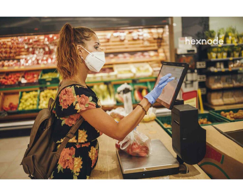Image of a person using device in kiosk mode to check out from a store.