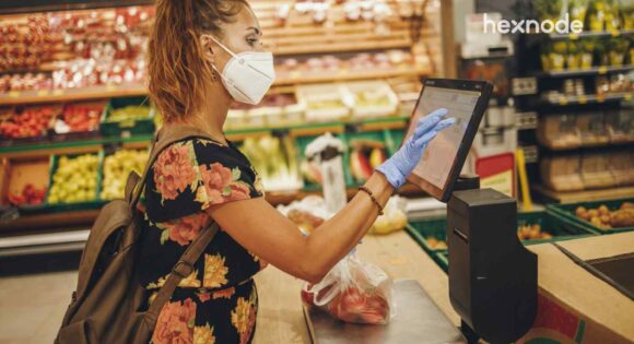 Image of a person using device in kiosk mode to check out from a store.