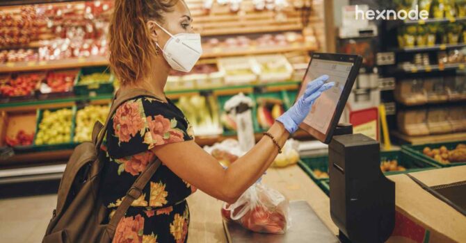 Image of a person using device in kiosk mode to check out from a store.